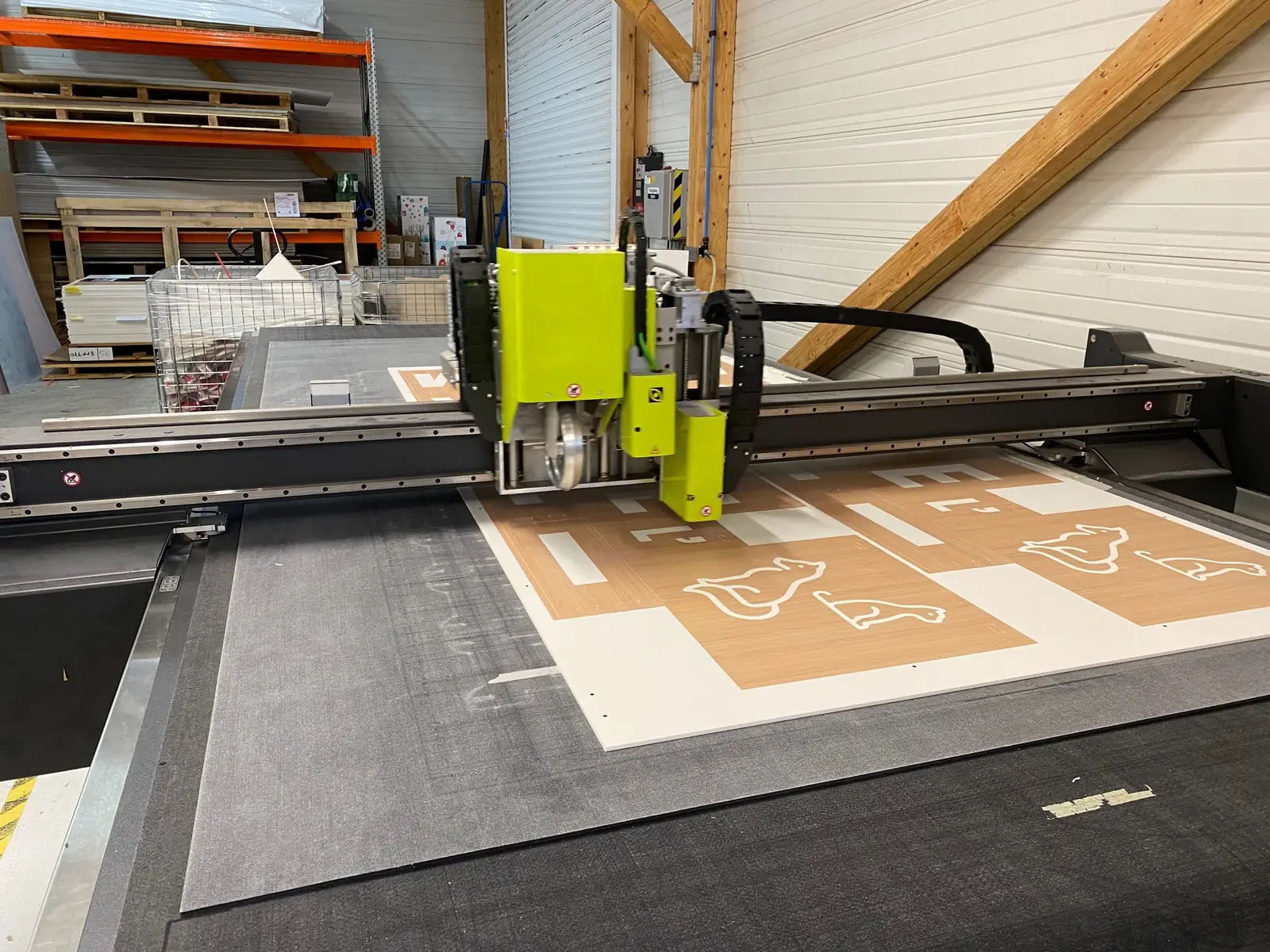 Kongsberg C24 d'occasion en production — découpe de panneau imprimé sur convoyeur